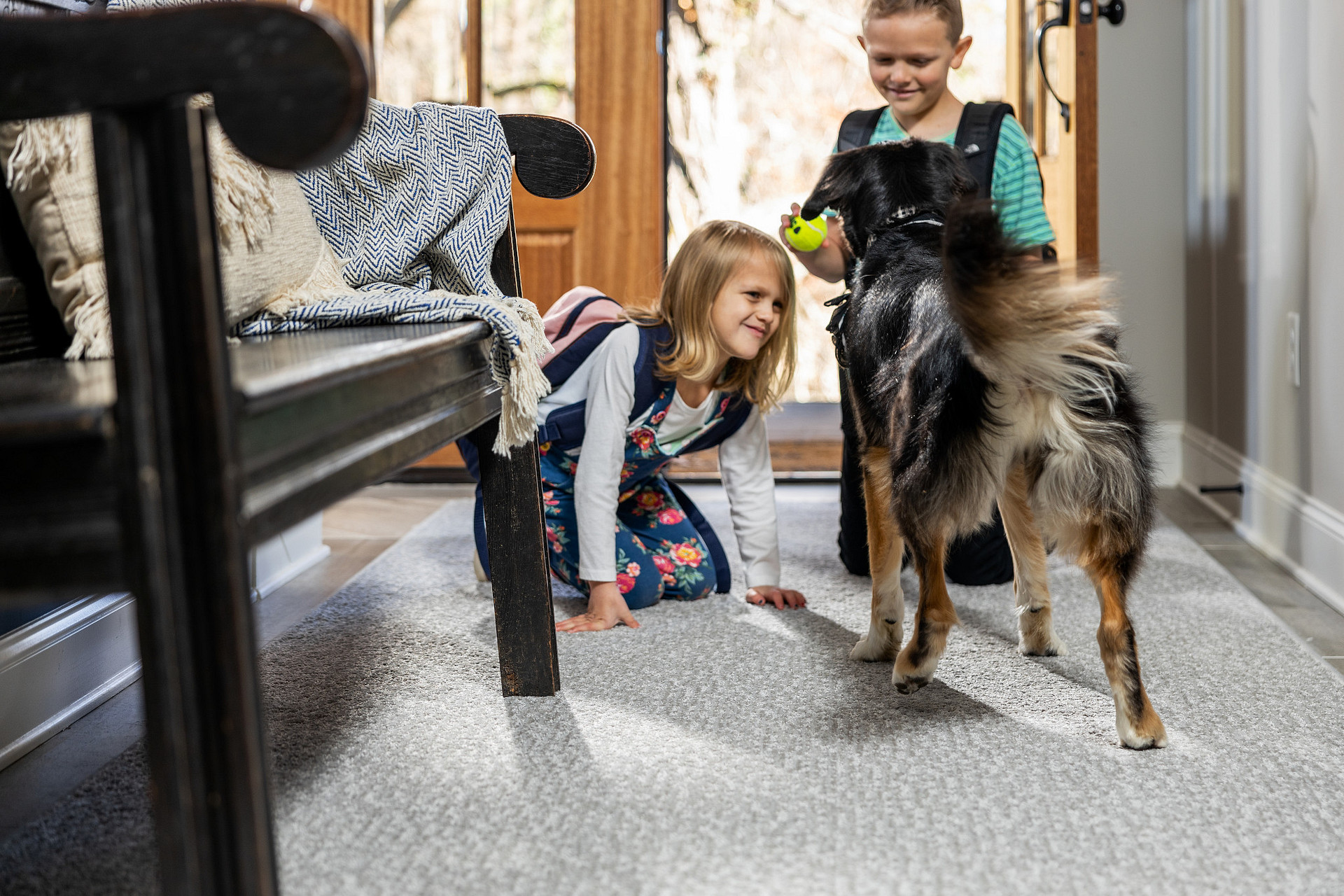 Kids plying with dog on carpet flooring | Christian Brothers Flooring & Interiors